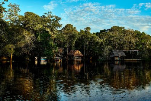 a group of trees and houses on a body of water at Amazon Muyuna Lodge - All Inclusive in Paraíso