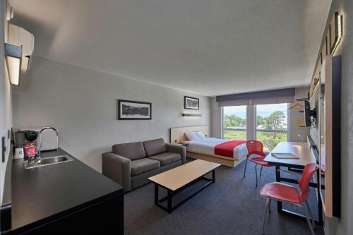 a hotel room with a couch and a bed at City Express by Marriott Cananea in Cananea