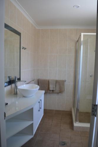 a bathroom with a sink and a shower at Cattlemans Country Motor Inn & Serviced Apartments in Dubbo