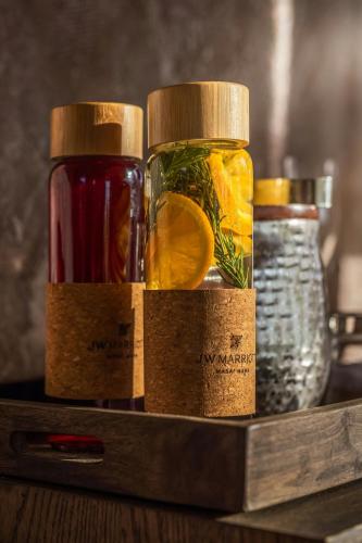 a shelf with three jars filled with different liquids at JW Marriott Masai Mara Lodge in Masai Mara