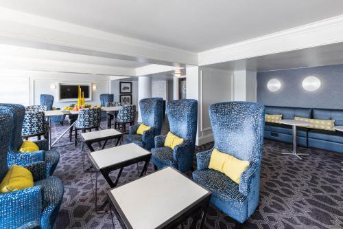 a waiting room with blue chairs and tables at Sheraton Indianapolis City Centre Hotel in Indianapolis