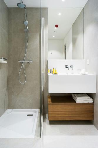 a bathroom with a white sink and a shower at Marriott Executive Apartments Brussels in Brussels