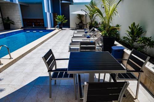 a row of tables and chairs next to a swimming pool at Zind Naaba Hotel in Lomé