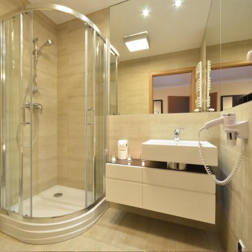 a bathroom with a shower and a sink at Resort Plaza Spa in Darlowko