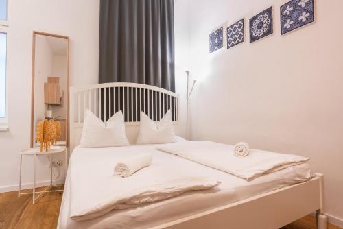 a white bed with white sheets and pillows on it at Vienna City Apartments - Metro 1160 Vienna in Vienna
