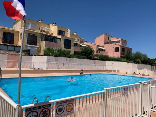 une personne se baignant dans une piscine avec drapeau dans l'établissement Les Terrasses du port, à Sausset-les-Pins