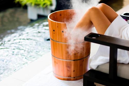 a woman sitting in a chair with steam coming out of a cup at The Ritz-Carlton, Kuala Lumpur in Kuala Lumpur