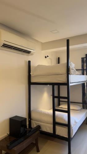 two bunk beds in a room with a tv at Dormstays in Udaipur