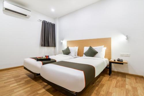 une chambre d'hôtel avec deux lits et un canapé dans l'établissement Super Townhouse 094 HOTEL MORO, à New Delhi