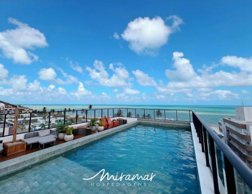 a swimming pool on the roof of a building overlooking the ocean at Get One - Bessa in Tambaú