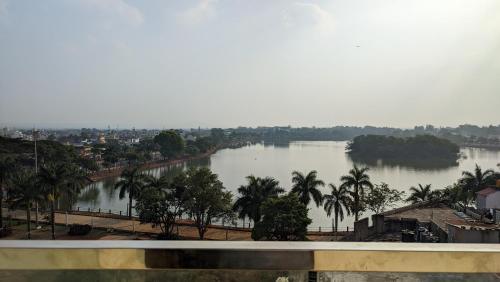 a view of a river with palm trees and a city at Mayur Belgaum Presidency Hotel & Spa in Belgaum