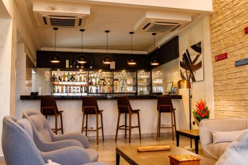 a bar in a restaurant with chairs and a counter at Zind Naaba Hotel in Lomé