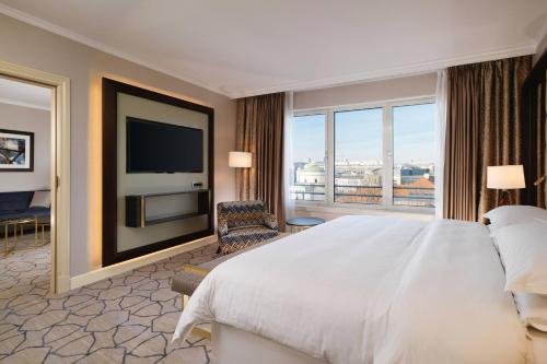a hotel room with a large bed and a television at Sheraton Grand Warsaw in Warsaw