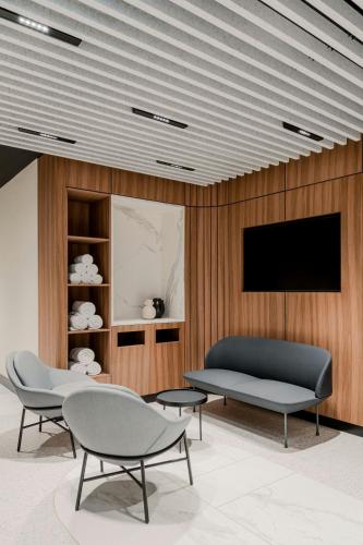 a living room with two chairs and a tv at Sheraton Grand Warsaw in Warsaw
