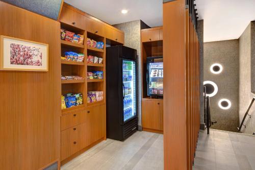 a kitchen with wooden cabinets and a refrigerator at SpringHill Suites by Marriott New York Midtown Manhattan/Park Ave in New York