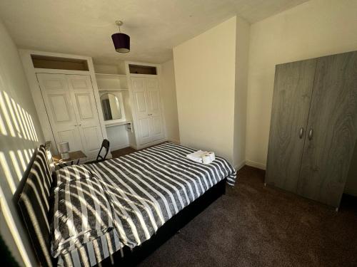 a bedroom with a bed with a black and white striped comforter at Double bed BW4 Accrington Burnley in Accrington