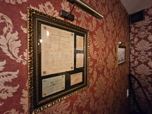 une photo encadrée sur un mur avec papier peint rouge dans l'établissement Appartement chic hyper centre, à Troyes