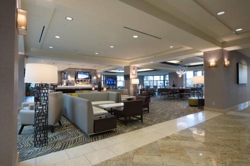 a lobby of a hotel with chairs and tables at Bakersfield Marriott at the Convention Center in Bakersfield