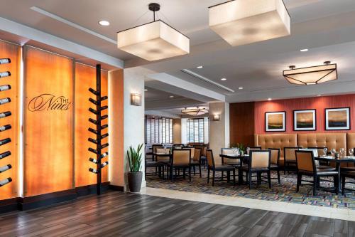 a dining room at a restaurant with tables and chairs at Bakersfield Marriott at the Convention Center in Bakersfield