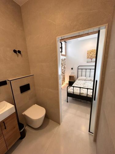 a bathroom with a toilet and a bed in a room at Apartamento La Fragua - A ESTRENAR - BRAND NEW in Chulilla
