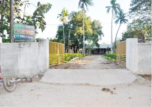 a bike parked in front of a fence at AS Garden Lodge in Mayiladuthurai