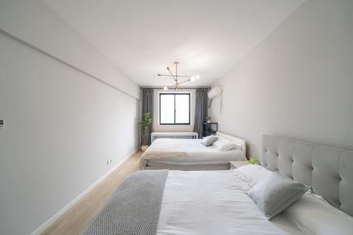 a bedroom with two beds and a window at Book and Bed-People's Square in Shanghai