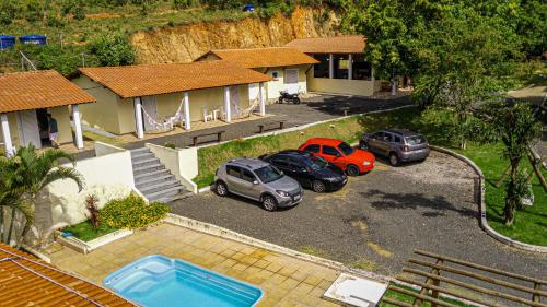 two cars parked in a parking lot in front of a house at Pousada Saint James in Águas de Lindóia