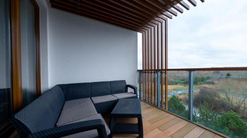 a balcony with a couch and a large window at Olympic Park I, Sun & Snow in Kołobrzeg
