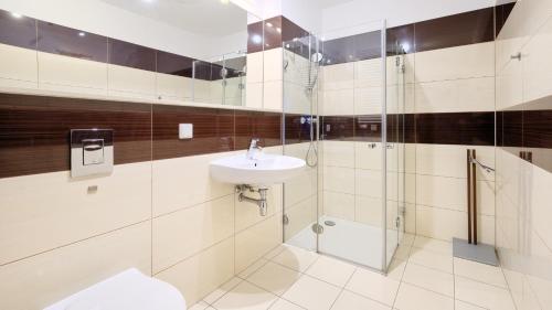 a bathroom with a sink and a shower at Olympic Park I, Sun & Snow in Kołobrzeg
