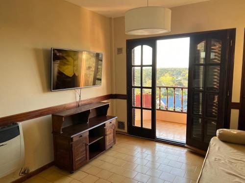 a living room with a view of a balcony at Bosque y Mar - 11 C - TAXCO in Villa Gesell
