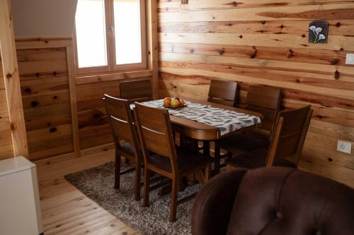 a dining room with a table and chairs in a cabin at Apartman Crni bor 2 Tara in Kaludjerske Bare