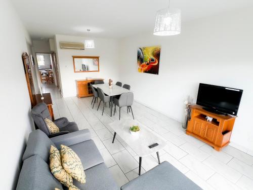 a living room with a couch and a table at Samos City Center, 2BR Sleeps 4 in Limassol
