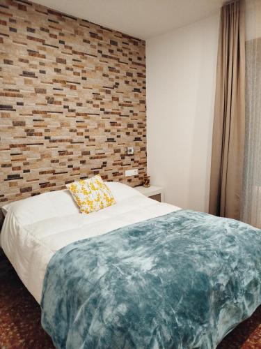 a bedroom with a bed with a brick wall at La Casa de la Mimosa in Córdoba