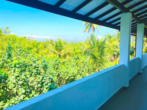 a view from the balcony of a house with palm trees at Sea wind in Mirissa