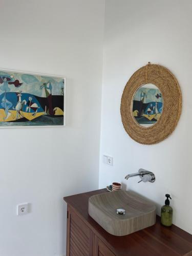 ein Badezimmer mit Waschbecken und Spiegel an der Wand in der Unterkunft Hostidy Villa Horacia Resort in Sanlúcar de Barrameda