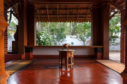 a room with a table and a large window at Sea Hut Homestay in Cochin