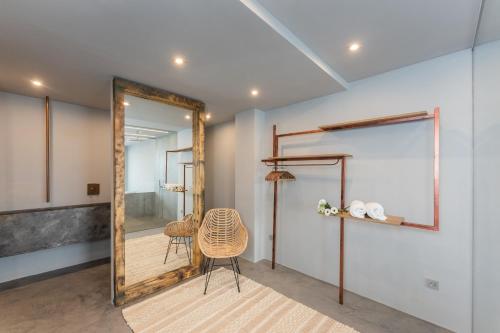 a mirror in a room with a table and a chair at Gold Suite Canteras by Canarias Homelidays in Las Palmas de Gran Canaria