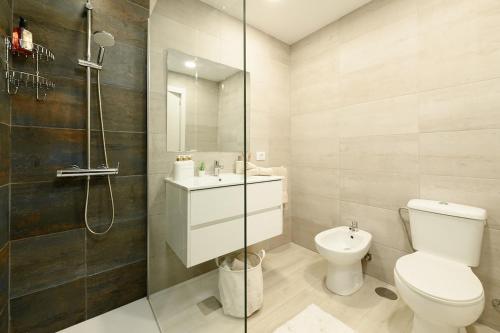 een badkamer met toilet, wastafel en douche bij Home2Rest at Los Gigantes - 1 min to beach, restaurants, city center - 1bdr in Acantilado de los Gigantes