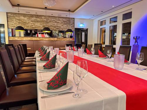 a long table in a restaurant with wine glasses at Willow Hotel Restaurant in Kötschlitz