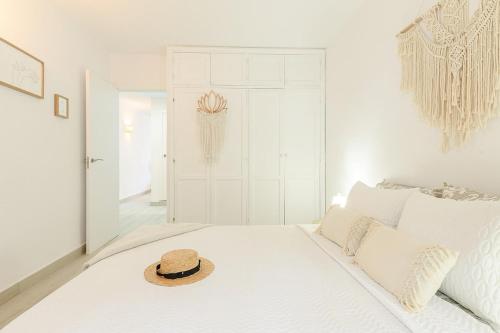 een hoed bovenop een bed in een kamer bij Home2Rest at Los Gigantes - 1 min to beach, restaurants, city center - 1bdr in Acantilado de los Gigantes