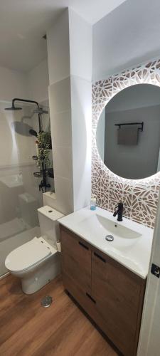 a bathroom with a sink and a toilet and a mirror at Océano Apartament in Punta del Hidalgo