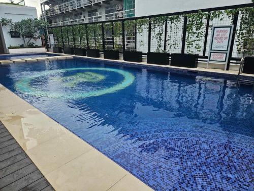 a large blue swimming pool in a building at 803 - Quiet Condo in City Centre in Davao City