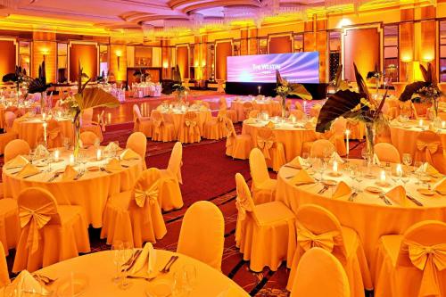 a banquet hall with white tables and chairs and a screen at The Westin Zagreb in Zagreb