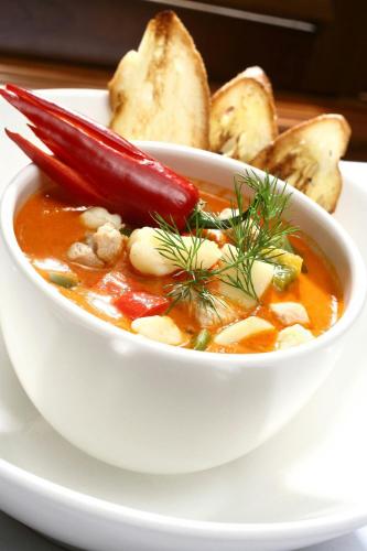 a bowl of soup on a plate with bread at The Westin Zagreb in Zagreb