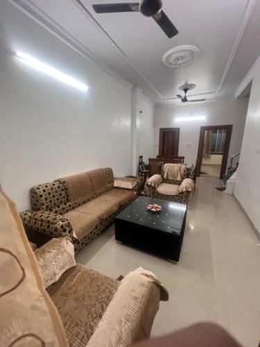 a living room with couches and a ceiling fan at Cozy Retreat In the heart of Jabalpur in Jabalpur