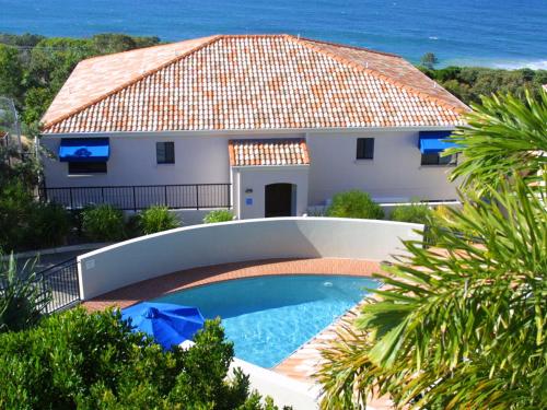 a house with a swimming pool next to the ocean at The Point Coolum in Coolum Beach