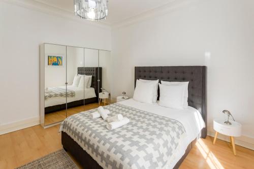 サン・マンデにあるAppartement cosy et confortable Paris St Mandéの大きなベッドと鏡のある寝室