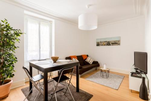 un salon avec une table et un canapé dans l'établissement Appartement cosy et confortable Paris St Mandé, à Saint-Mandé