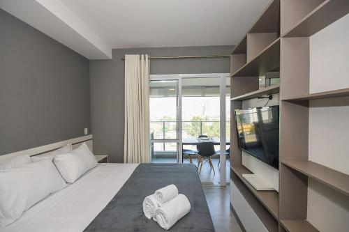 Un dormitorio con una cama, un televisor y una mesa. en SP Stays Emotion - Brooklin, en São Paulo