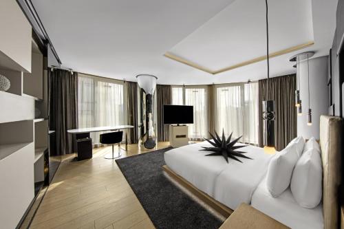 a bedroom with a large white bed and a television at W London in London